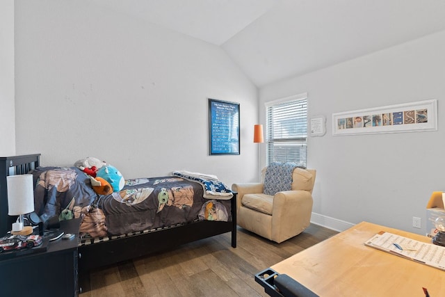 bedroom with vaulted ceiling, wood finished floors, and baseboards