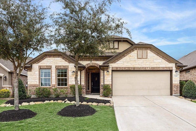 french provincial home with brick siding, concrete driveway, an attached garage, stone siding, and a front lawn