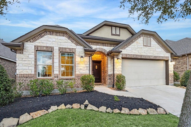 french provincial home featuring driveway, stone siding, an attached garage, and brick siding