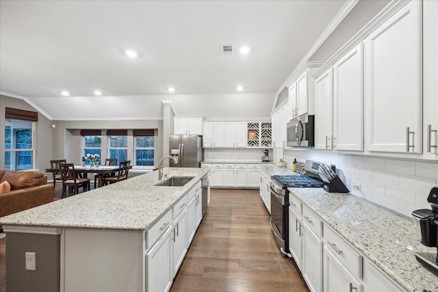 kitchen with visible vents, dark wood-style floors, a sink, stainless steel appliances, and backsplash