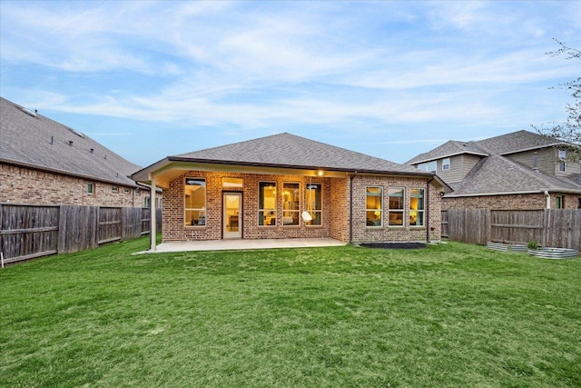 back of house featuring brick siding, a patio, a fenced backyard, and a lawn