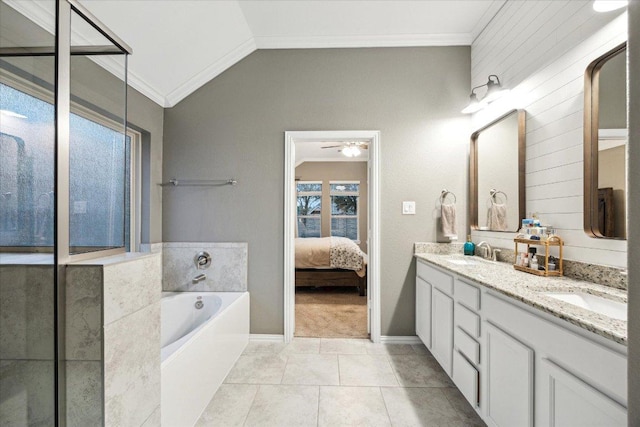 ensuite bathroom featuring ornamental molding, vaulted ceiling, and a sink