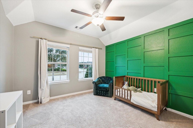 carpeted bedroom featuring a ceiling fan, lofted ceiling, visible vents, and baseboards