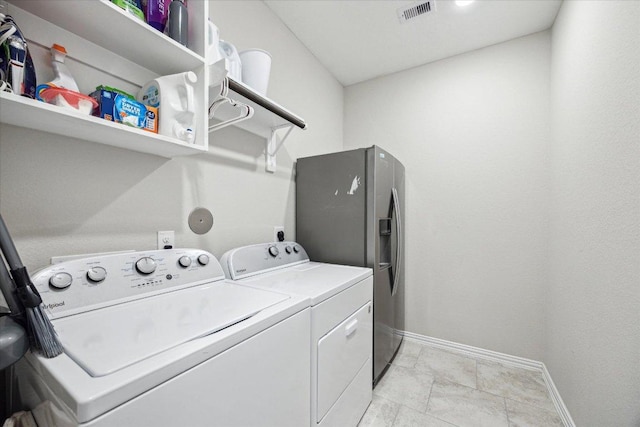 laundry room featuring laundry area, washing machine and dryer, visible vents, and baseboards