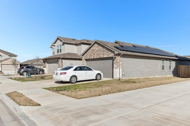 view of property exterior with concrete driveway, brick siding, and fence