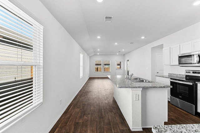 kitchen featuring visible vents, appliances with stainless steel finishes, light stone counters, dark wood-type flooring, and a sink