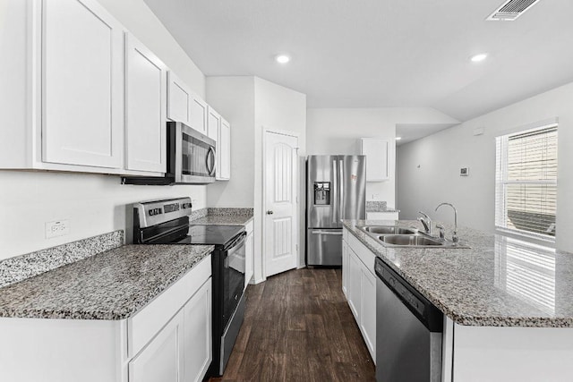 kitchen with visible vents, dark wood-style floors, appliances with stainless steel finishes, a kitchen island with sink, and a sink