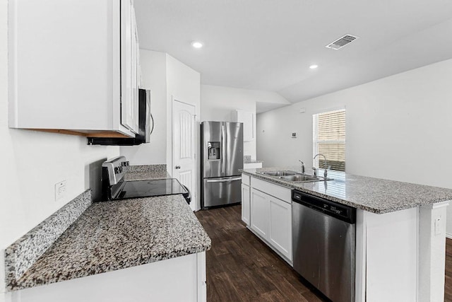 kitchen featuring visible vents, dark wood finished floors, appliances with stainless steel finishes, a kitchen island with sink, and a sink