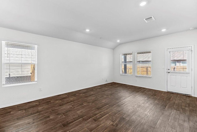 empty room with lofted ceiling, visible vents, wood finished floors, and recessed lighting