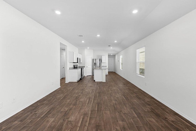 unfurnished living room featuring baseboards, visible vents, dark wood finished floors, and recessed lighting