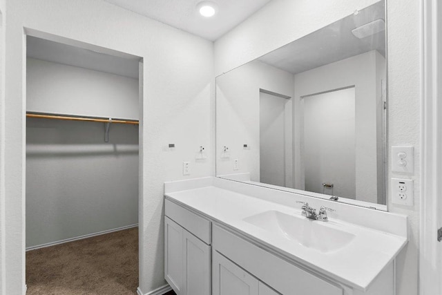 bathroom with a spacious closet and vanity