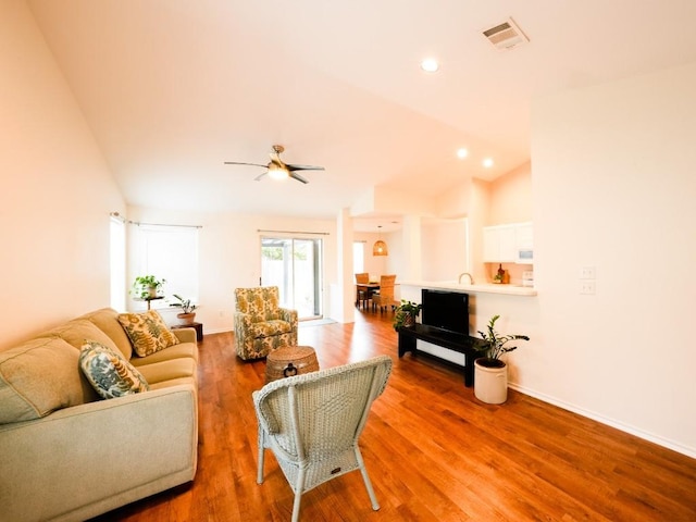 living area with baseboards, visible vents, wood finished floors, vaulted ceiling, and recessed lighting