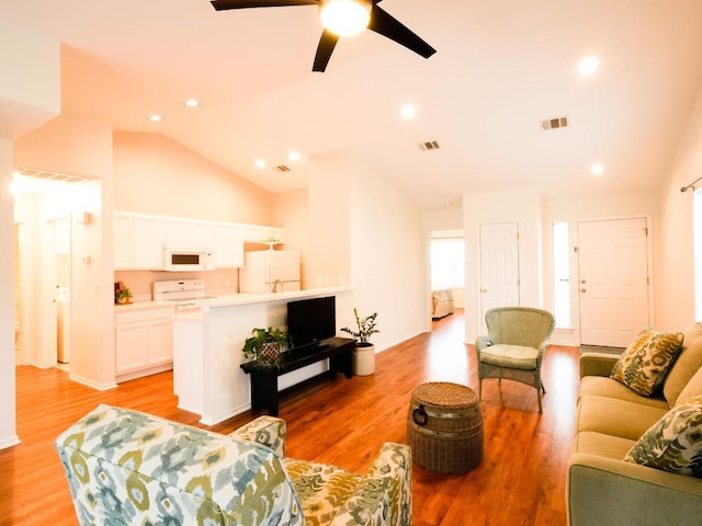 living area with lofted ceiling, visible vents, light wood-style flooring, and recessed lighting