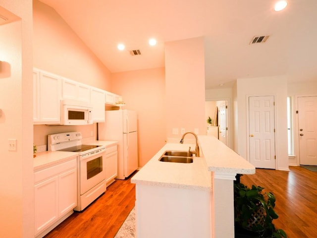 kitchen with white appliances, visible vents, a sink, and light wood finished floors