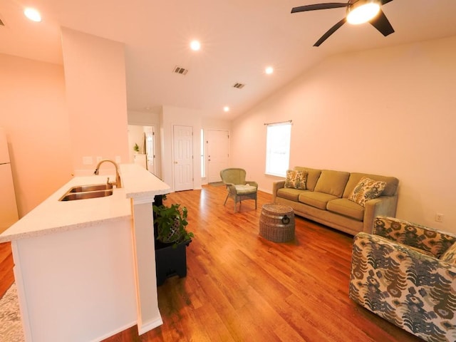 living room with vaulted ceiling, wood finished floors, visible vents, and recessed lighting