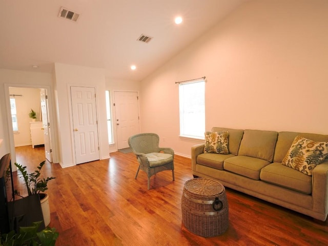 living room with lofted ceiling, wood finished floors, visible vents, and recessed lighting