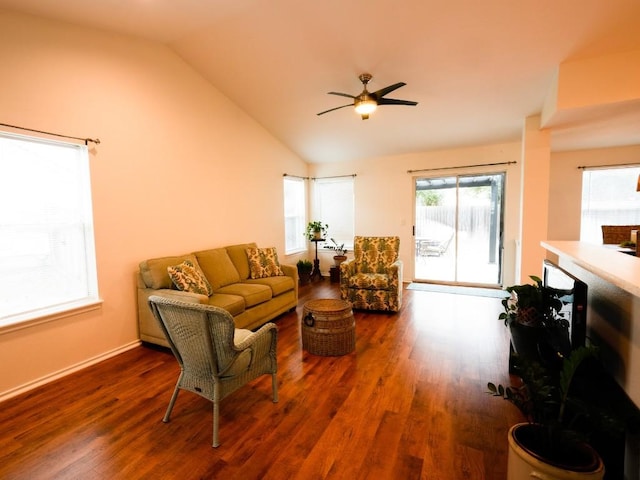 living room featuring ceiling fan, vaulted ceiling, baseboards, and wood finished floors