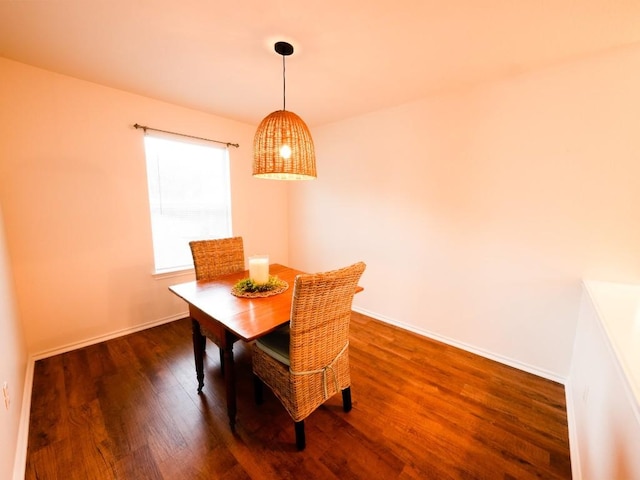 dining area with dark wood-style flooring and baseboards