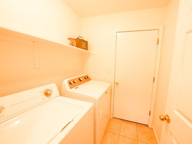 washroom featuring laundry area, washer and clothes dryer, and light tile patterned flooring