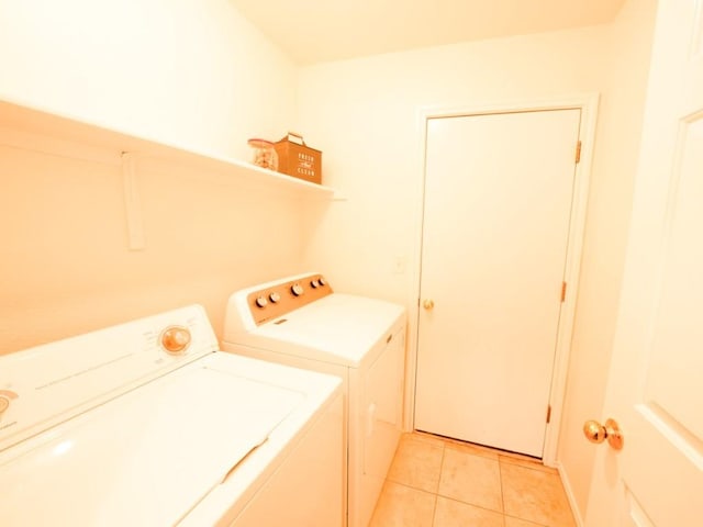 laundry area with washer and dryer, laundry area, and light tile patterned floors