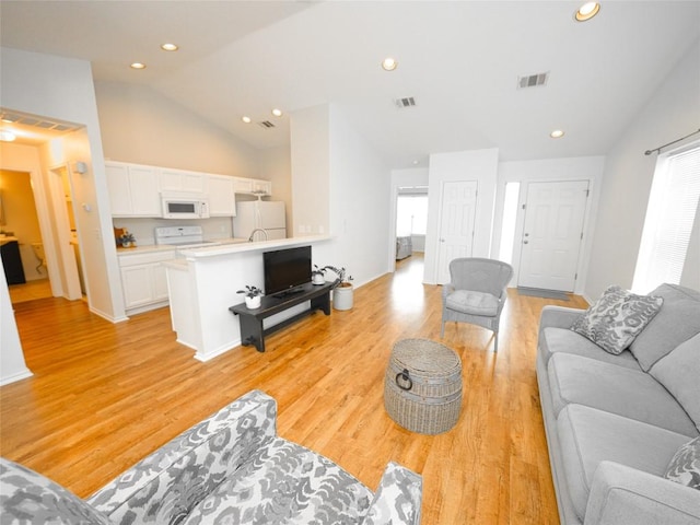 living room with recessed lighting, vaulted ceiling, light wood-type flooring, and visible vents