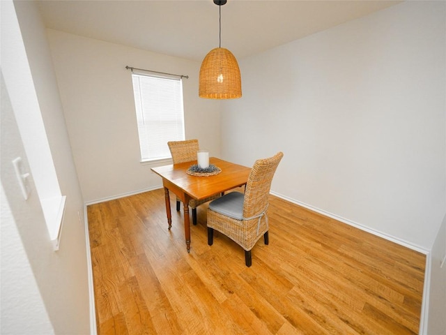 dining space featuring light wood-style floors and baseboards