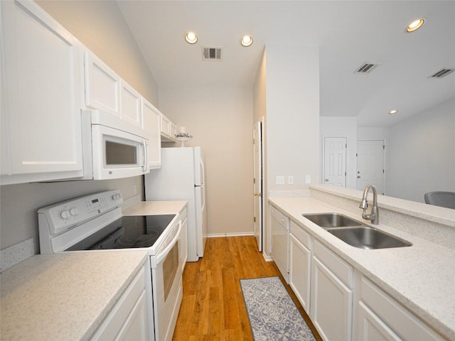 kitchen with a sink, white appliances, and visible vents