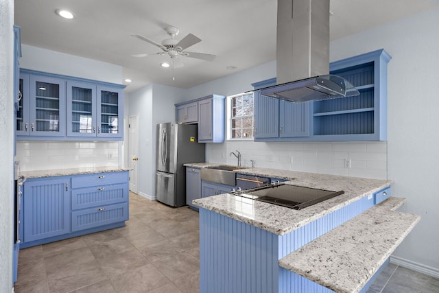 kitchen with appliances with stainless steel finishes, blue cabinets, island exhaust hood, and a peninsula