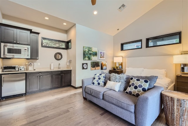 living area featuring light wood finished floors, visible vents, vaulted ceiling, and recessed lighting