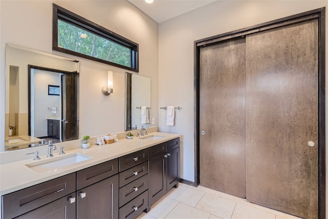 bathroom with double vanity, tile patterned flooring, and a sink