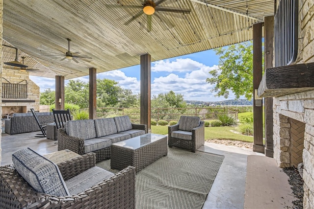 view of patio featuring an outdoor living space with a fireplace and a ceiling fan