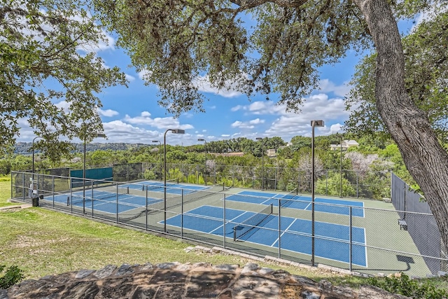 view of sport court featuring fence and a yard