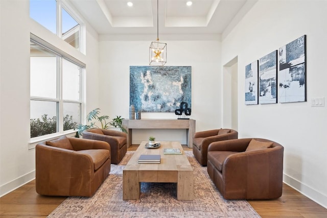 living area with baseboards, a wealth of natural light, and wood finished floors