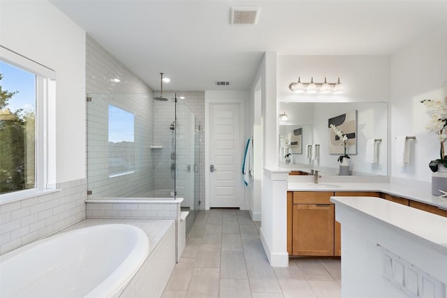 full bathroom with visible vents, tile patterned flooring, a shower stall, a garden tub, and vanity