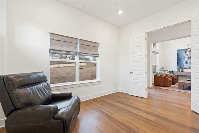 living area featuring baseboards, wood finished floors, and recessed lighting