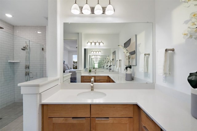 bathroom with a shower stall, connected bathroom, and vanity