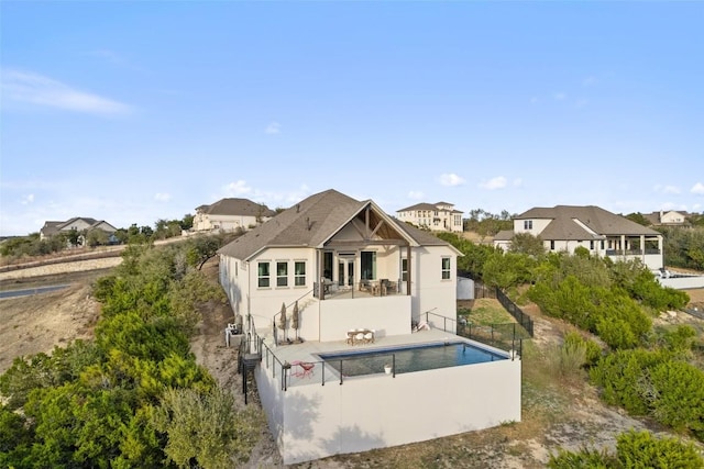 back of property with fence, a fenced in pool, and a patio