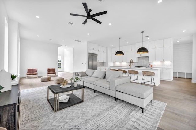 living area featuring light wood-style flooring, visible vents, and recessed lighting