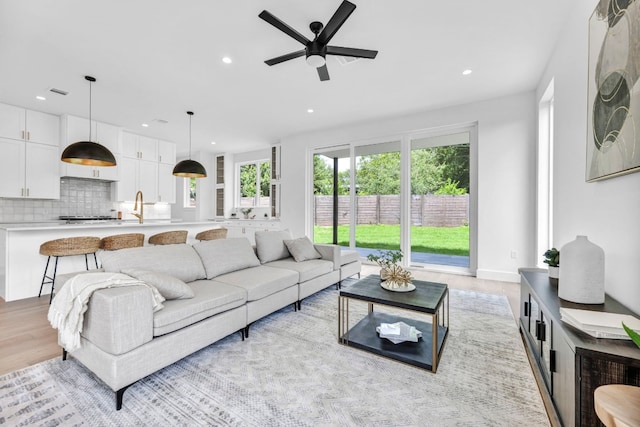 living room with light wood-style floors, visible vents, a ceiling fan, and recessed lighting