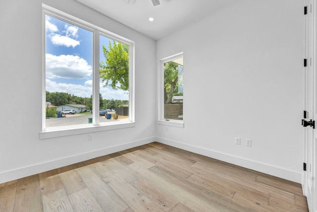 spare room featuring recessed lighting, ceiling fan, light wood-style flooring, and baseboards