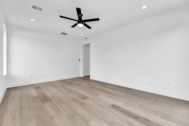 empty room featuring baseboards, visible vents, and light wood finished floors