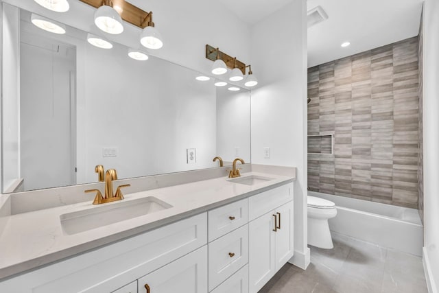 full bath with double vanity, a sink, toilet, and tile patterned floors