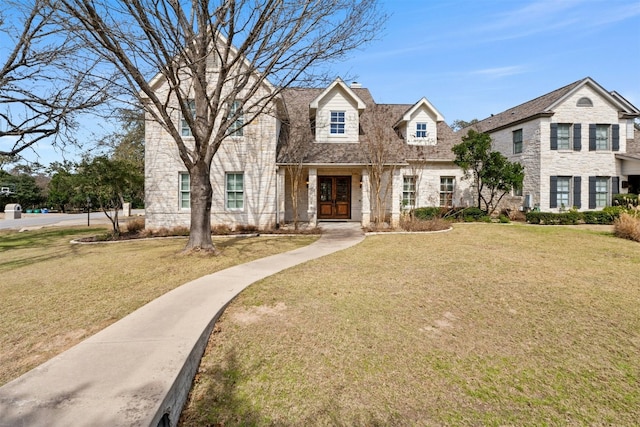 view of front of property featuring stone siding, a front yard, and french doors