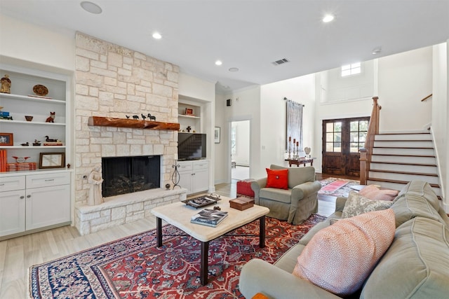 625 Robin Dale Ct, Lakeway, TX 78734 - living area with stairs, light wood-style flooring, built in shelves, a stone fireplace, and recessed lighting