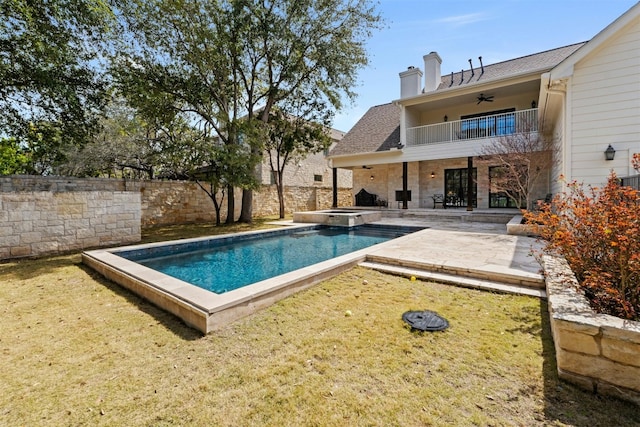 view of pool with a fenced backyard, a pool with connected hot tub, a ceiling fan, a yard, and a patio area