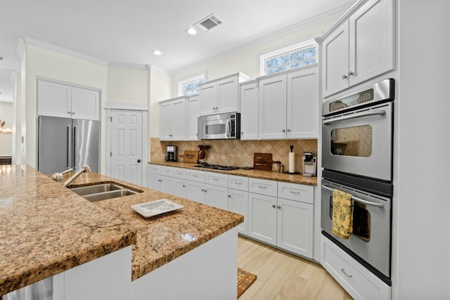 625 Robin Dale Ct, Lakeway, TX 78734 - kitchen featuring stainless steel appliances, a sink, ornamental molding, light stone counters, and tasteful backsplash