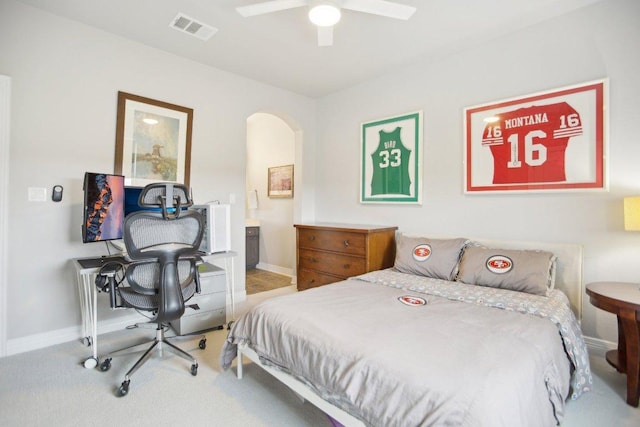 bedroom with arched walkways, visible vents, connected bathroom, and baseboards