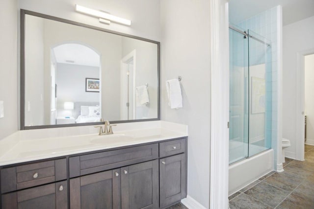 bathroom featuring toilet, baseboards, and vanity