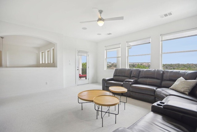 living room with carpet floors, a ceiling fan, visible vents, and baseboards