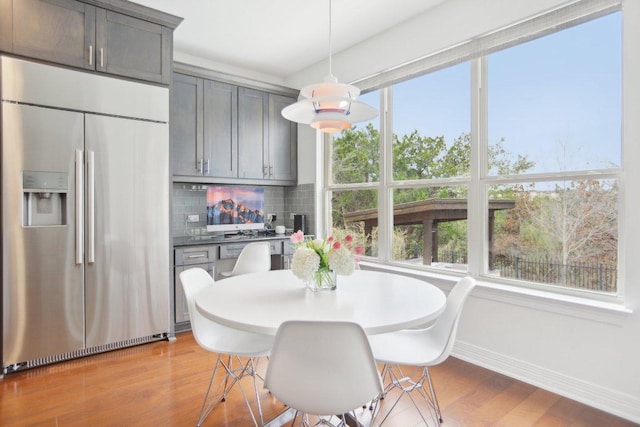 dining space with baseboards and wood finished floors